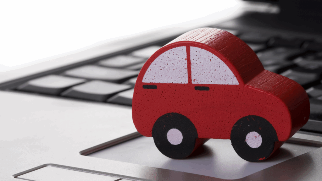 Symbolisches rotes Auto auf Laptop Tastatur als Hinweis auf die Online Abfrage der Punkte beim KBA Flensburg