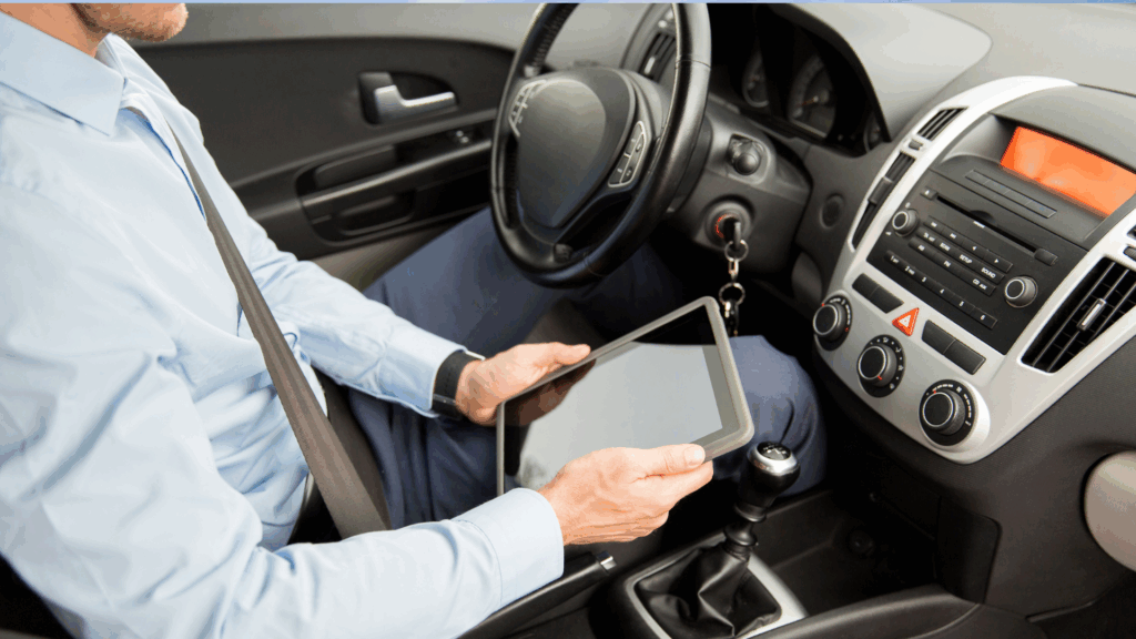 Mann prüft Punkte Auskunft Flensburg mit Tablet im Auto – digitale Kontrolle des Punktestands Ein Mann sitzt angeschnallt im Auto und hält ein Tablet in der Hand. Er nutzt die digitale Möglichkeit, seine Punkte Auskunft Flensburg online abzurufen, um seinen Punktestand im Fahreignungsregister zu überprüfen.