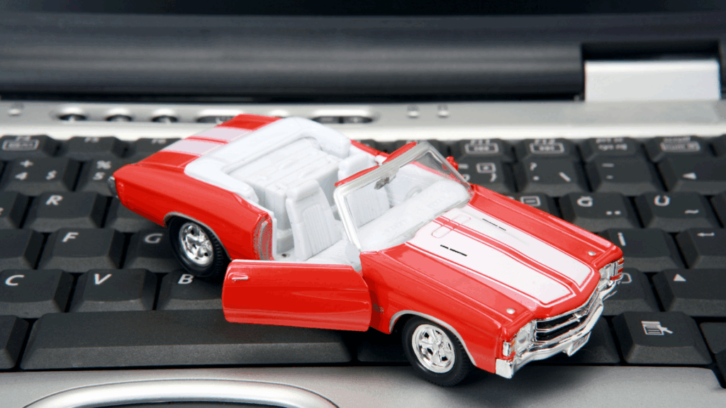 Symbolbild für Flensburg Punkte Auto: Modellauto auf Tastatur steht für die digitale Punkteabfrage beim Kraftfahrt-Bundesamt