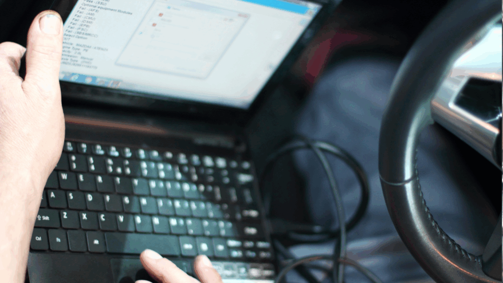 Nahaufnahme einer Punkteabfrage in Flensburg am Laptop im Auto – KBA-Auskunft über Punktestand digital beantragen