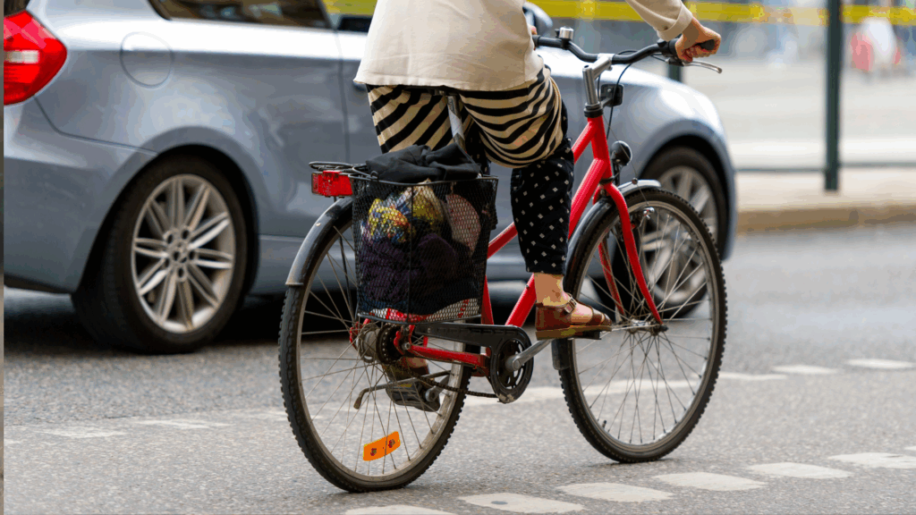 Fahrradfahrerin im Straßenverkehr neben Auto – Symbolbild für Regelverstöße und Punktekatalog in Flensburg