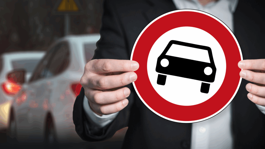 Ein Mann hält ein Fahrverbotsschild in der Hand – Symbolbild für Fahrverbote und die Auswirkungen von Punkten in Flensburg auf die Fahrerlaubnis