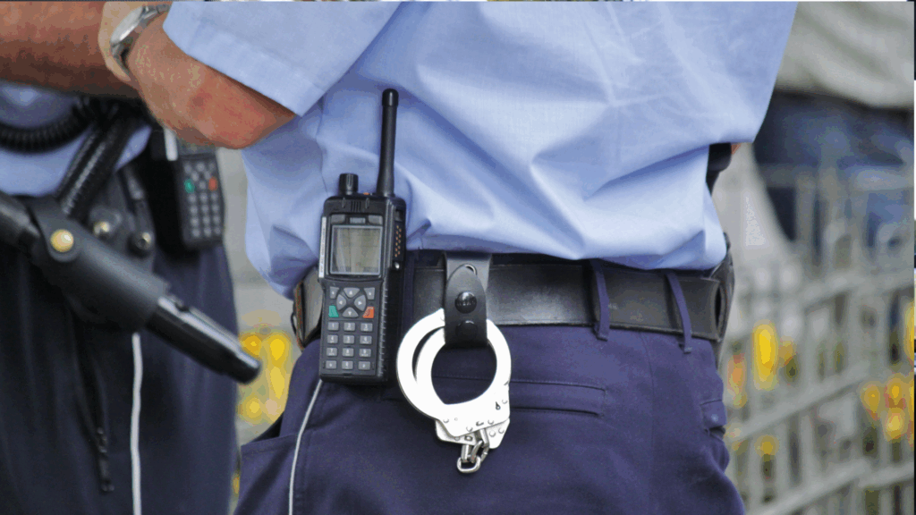 Polizist mit Handschellen und Funkgerät am Gürtel – Symbol für Verkehrsüberwachung und Punkte im Fahreignungsregister Flensburg.