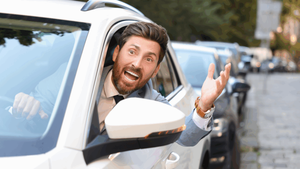 Ein aufgebrachter Mann am Steuer eines weißen Autos – Symbolbild für Verkehrssünder und drohenden Führerscheinverlust in Flensburg